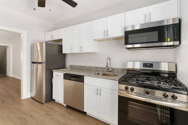 Kitchen with white cabinets, granite counters, a stainless steel range, dishwasher and microwave