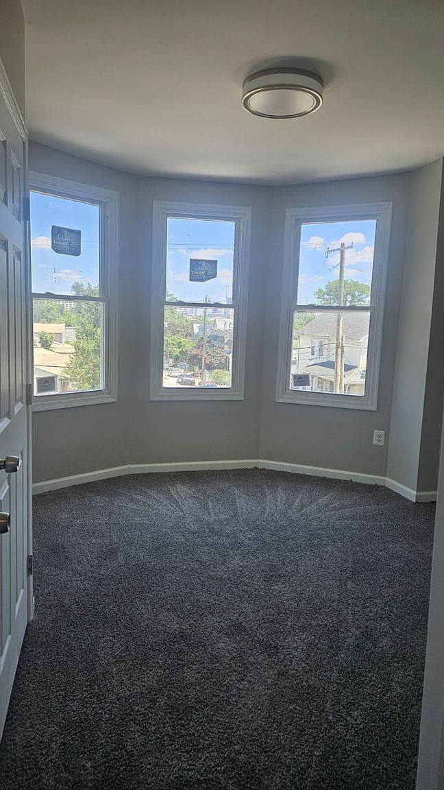 Carpeted bedroom with a three-window bay