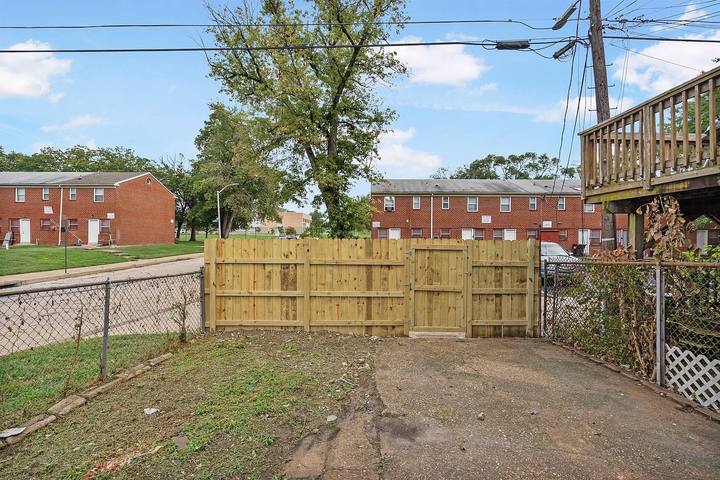 Fenced back yard with a wood privacy gate behind the townhouse